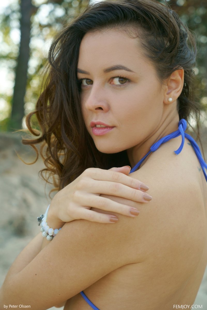 Naked nudist poses on sandy beach